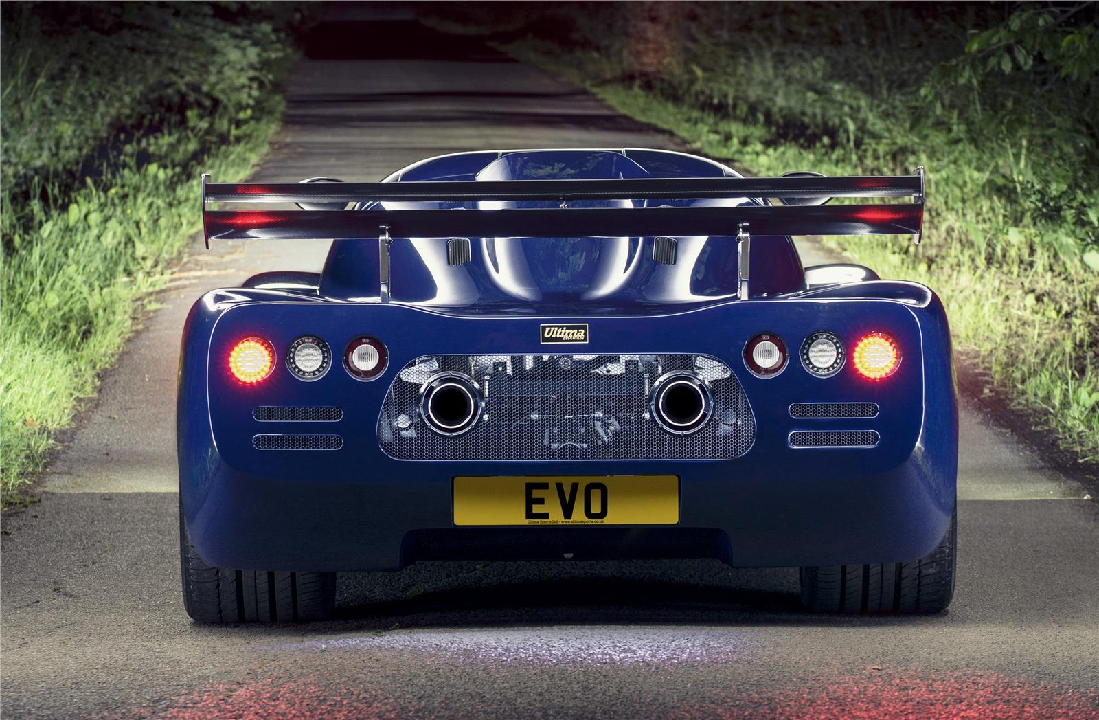Rear view of a black Ultima Evolution Coupe on the road