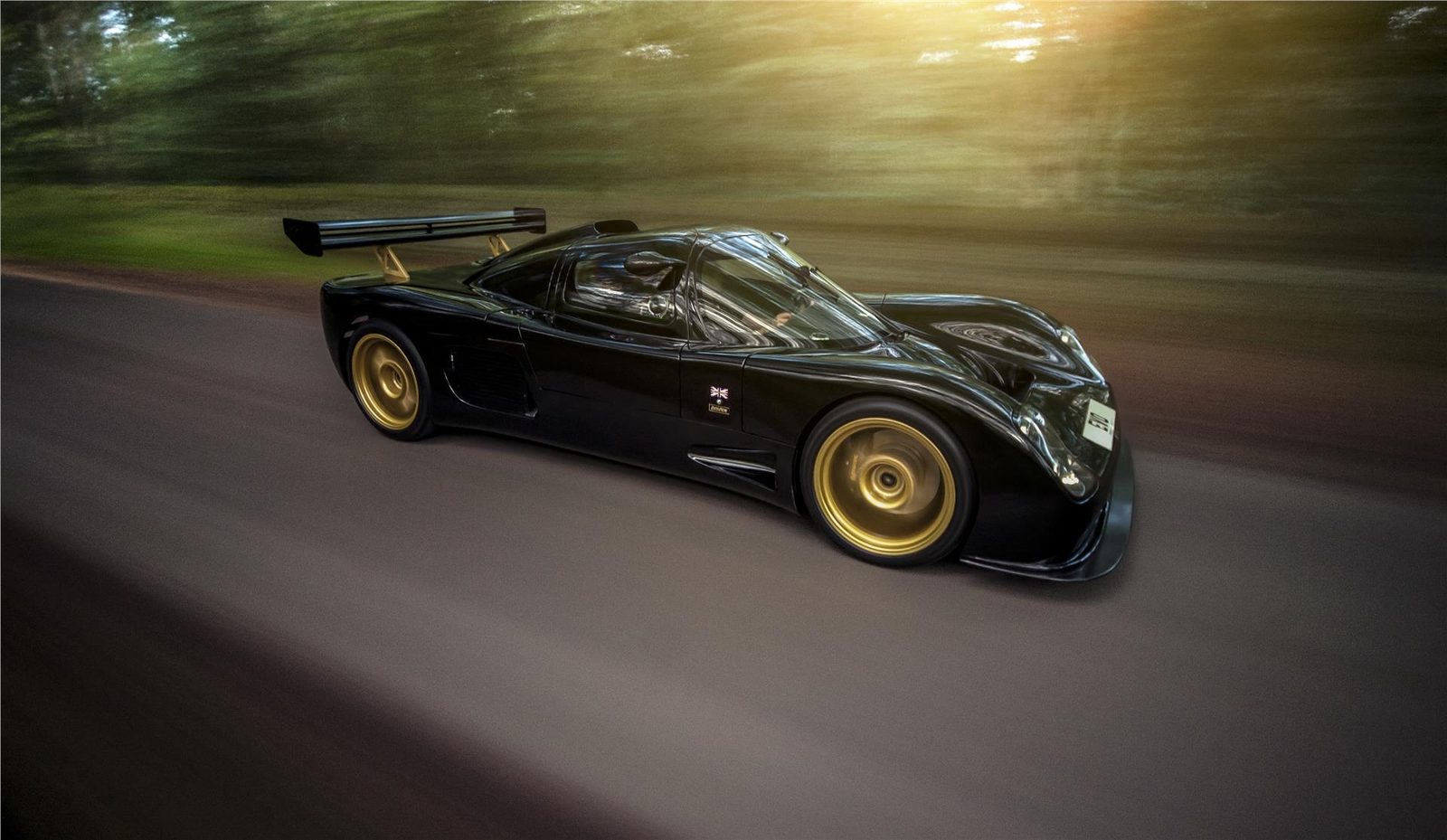 Black Ultima Evolution Coupe photographed in motion