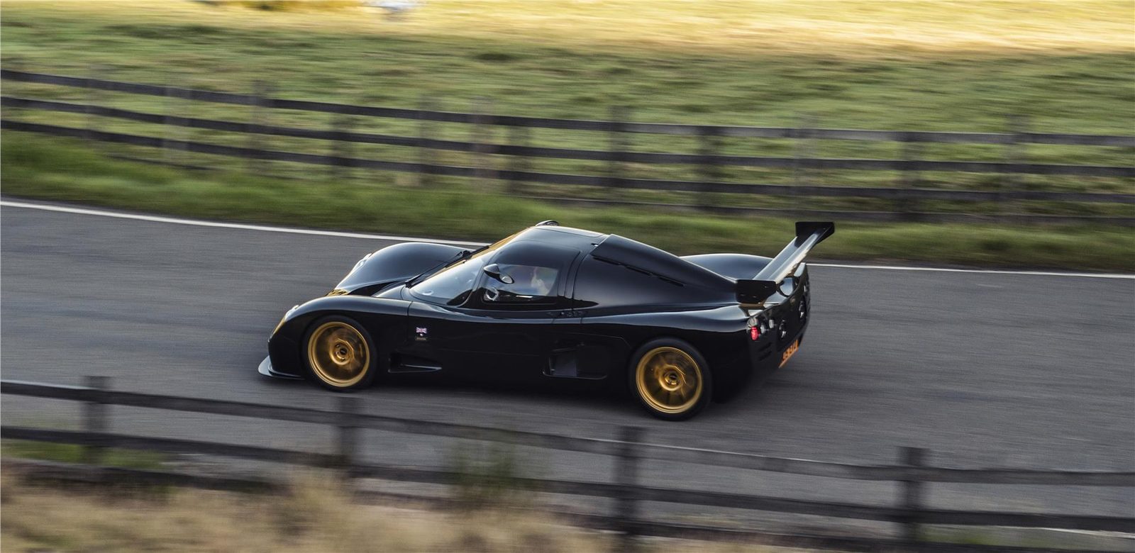 Black Ultima Evolution Coupe in motion at a circuit