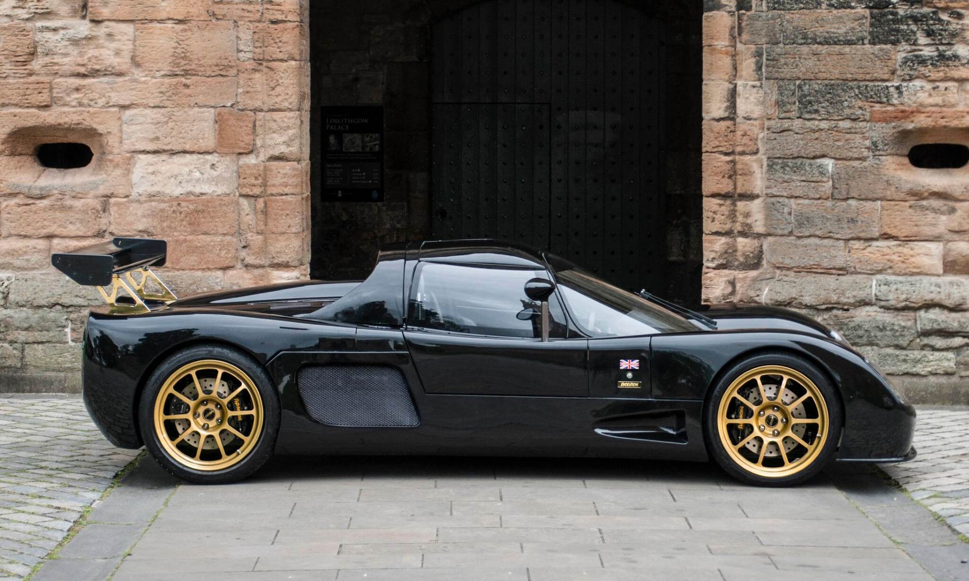 A black Ultima Evolution Coupe photographed in side profile