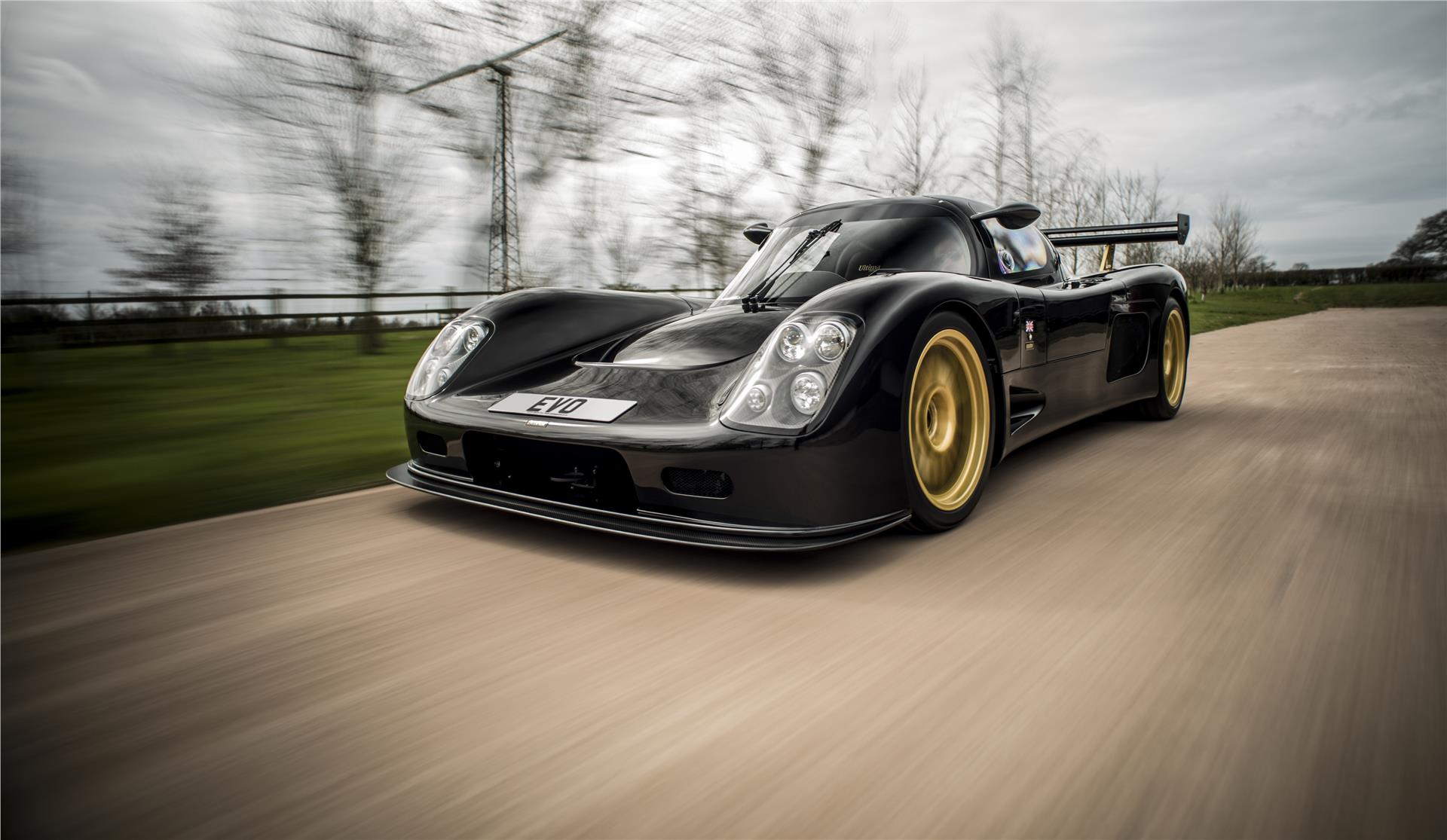 A black Ultima Evolution Coupe photographed from the front on a road