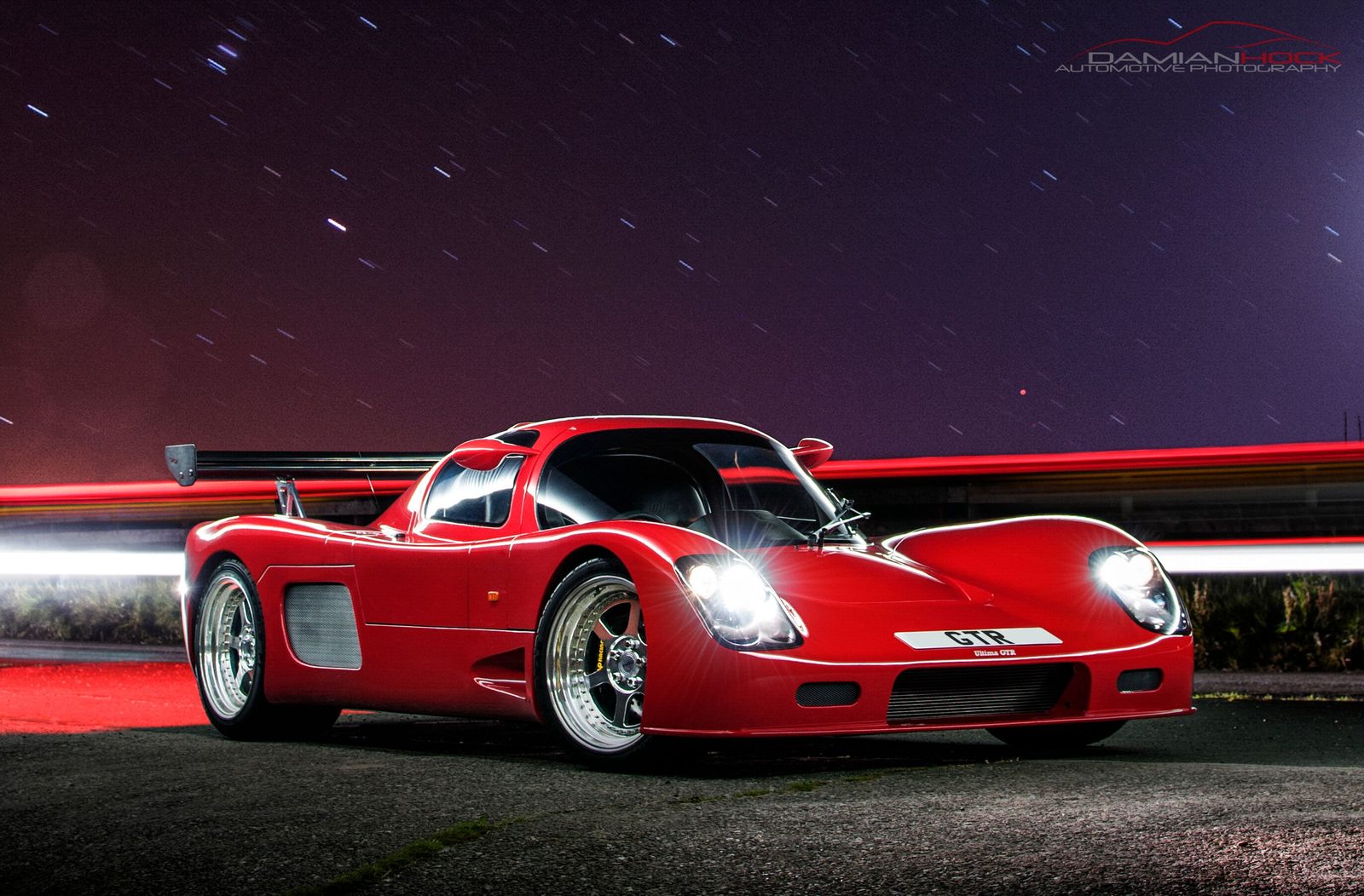 Red Ultima GTR photographed by night using a long exposure
