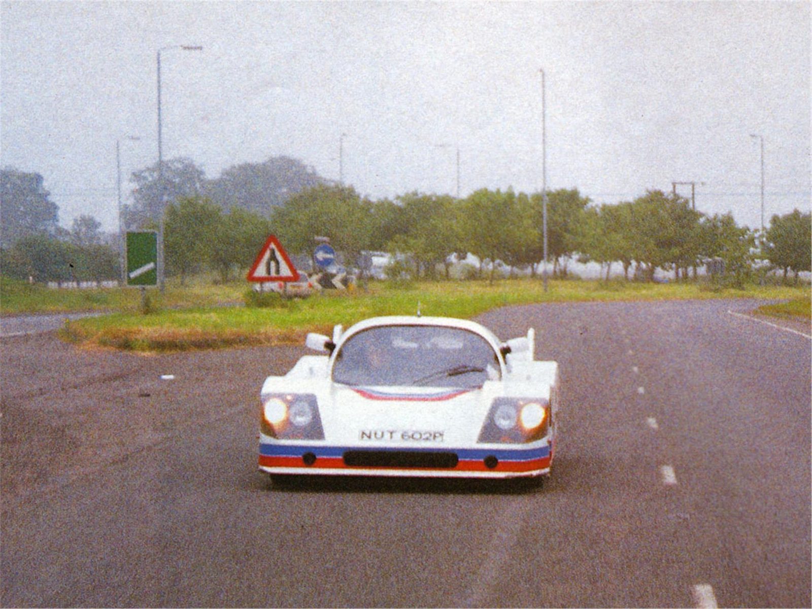 A white early Ultima photographed head-on outdoors