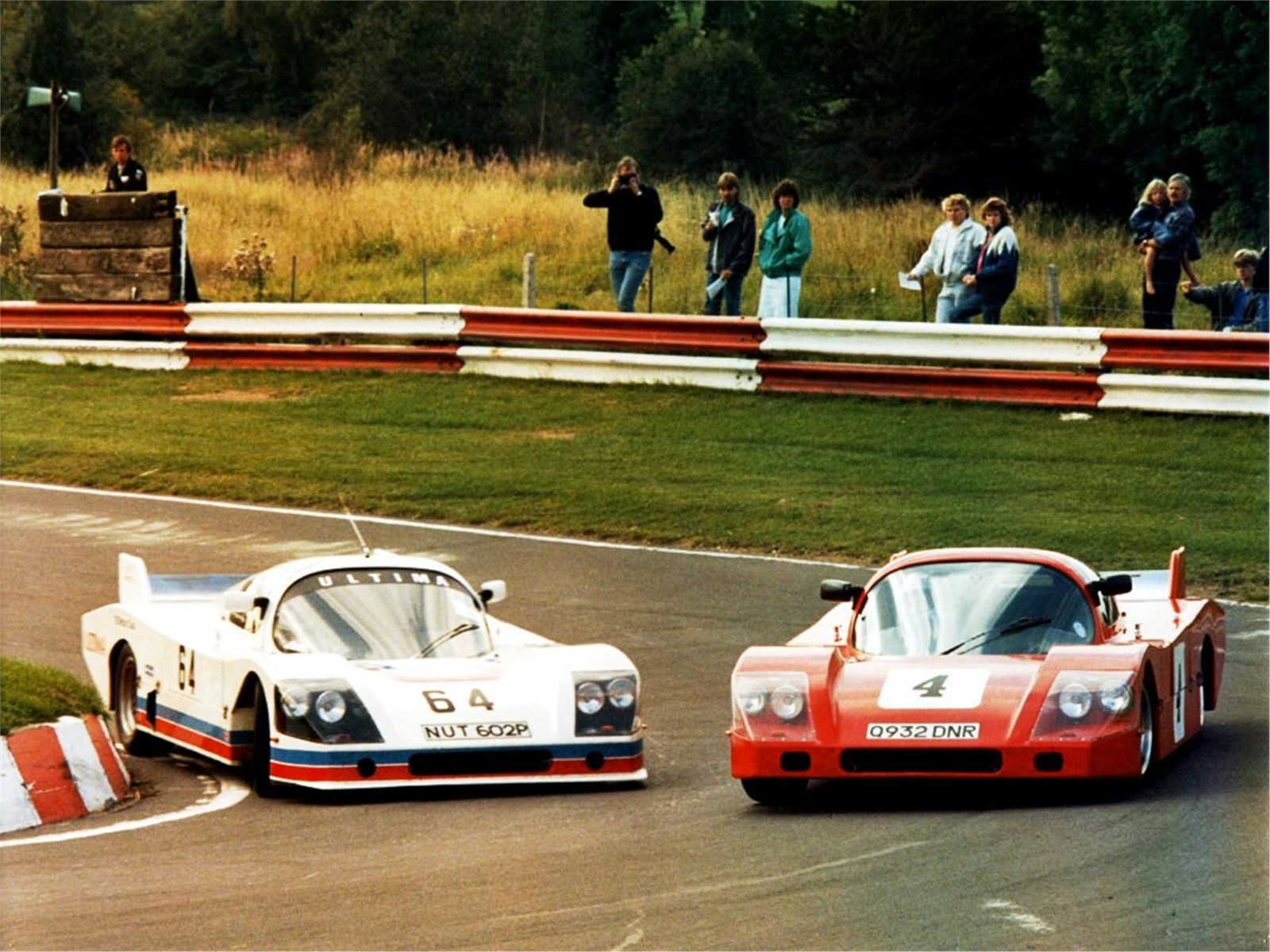 White and red early Ultimas at a race circuit