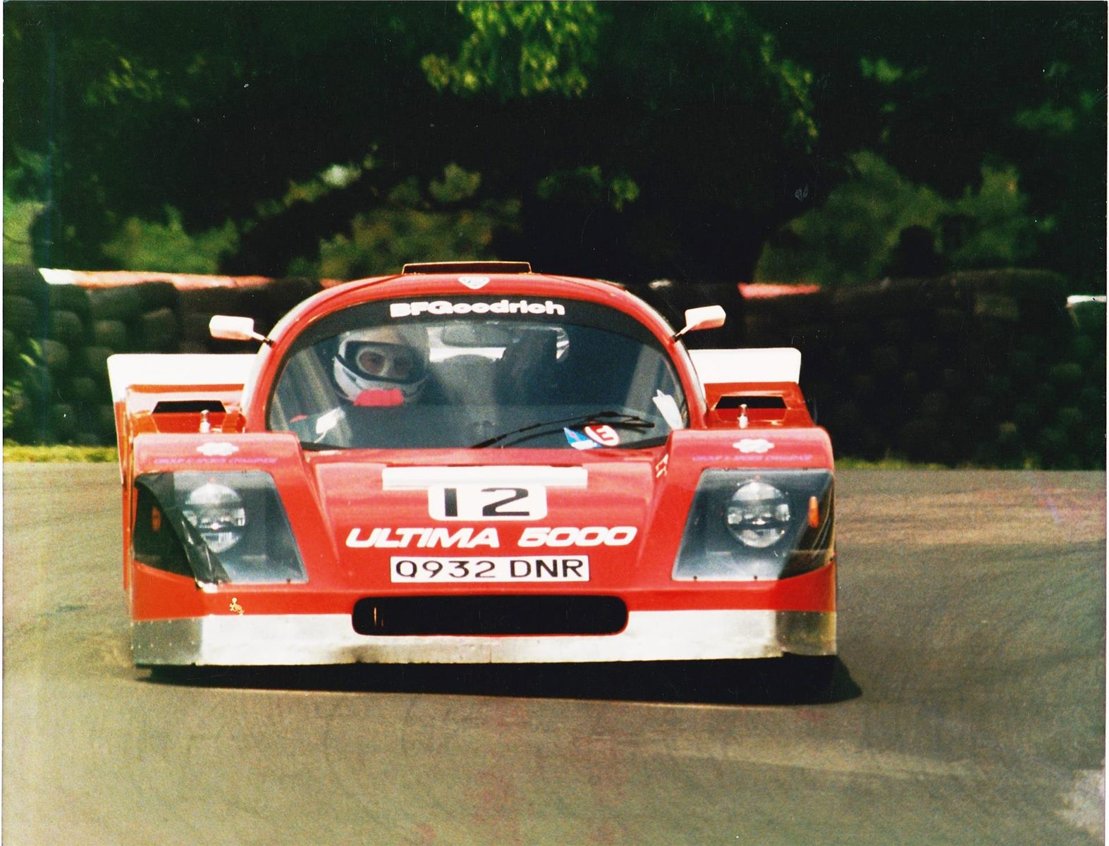 Red early Ultima facing the camera at a circuit