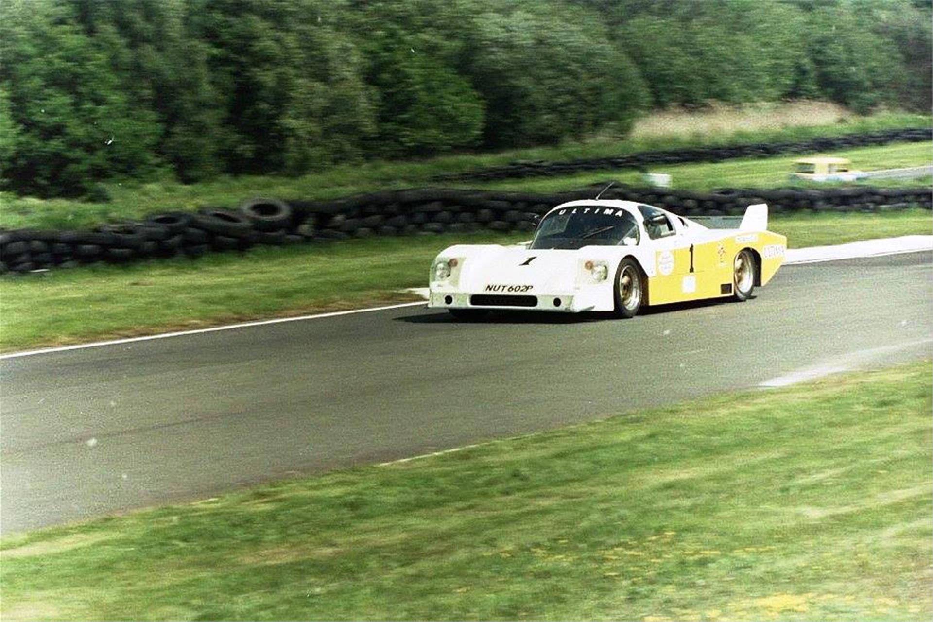 A yellow and white Ultima Mk2A photographed on a race circuit