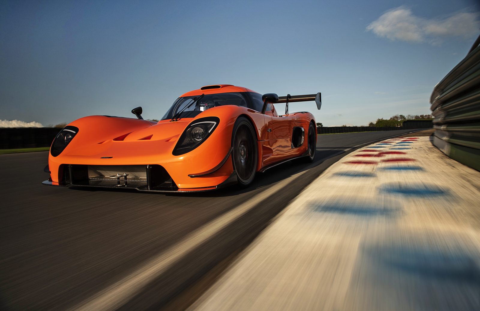 Orange Ultima RS photographed from the front at a circuit