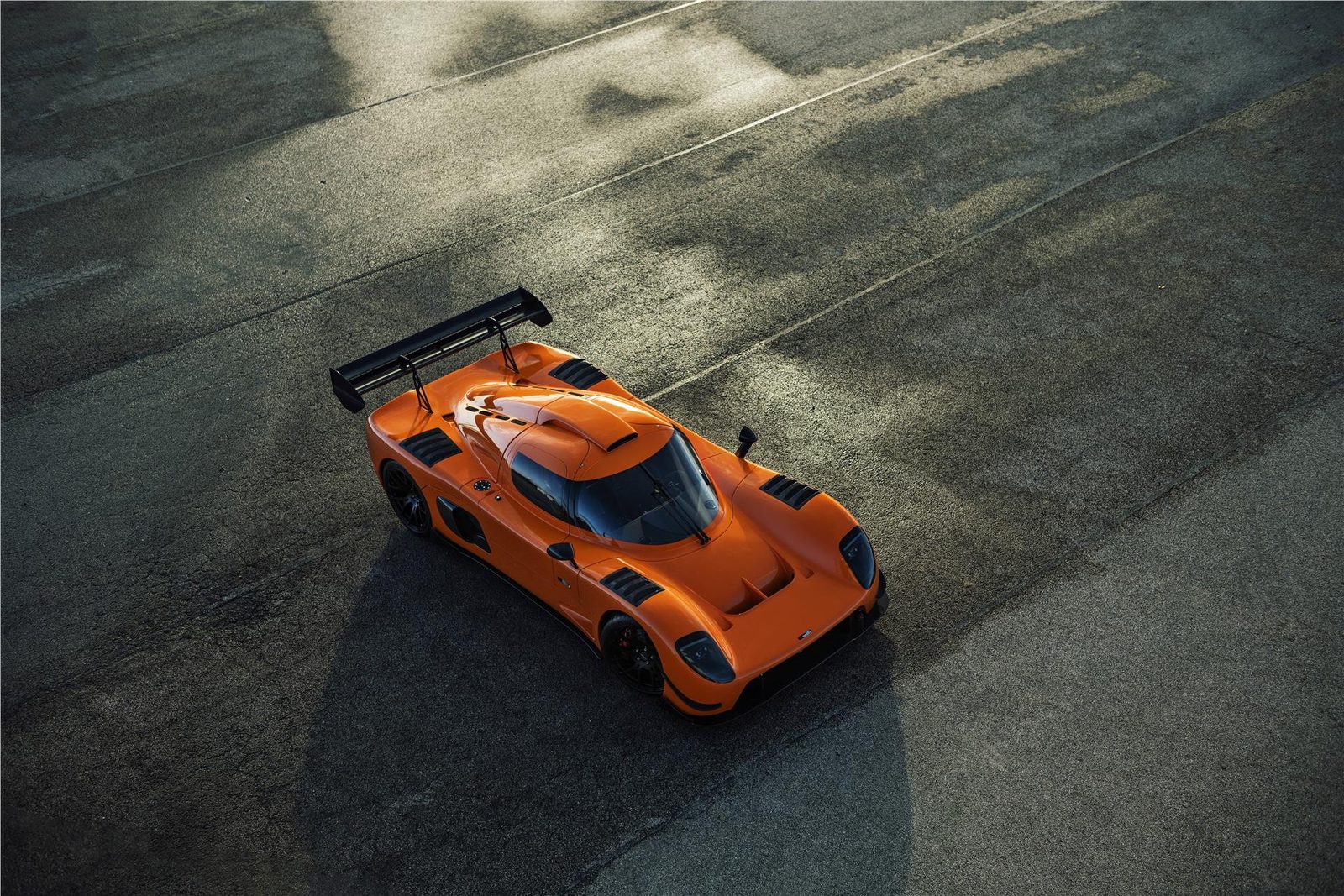 Orange Ultima RS viewed from above at a circuit