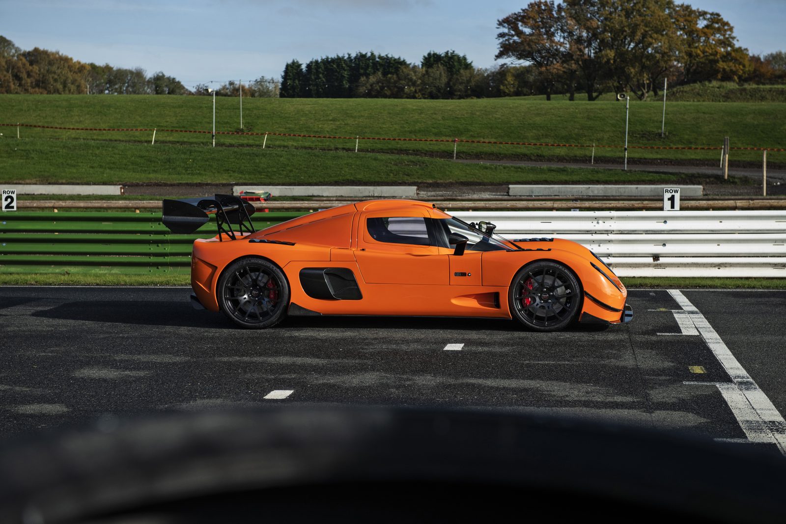 Orange Ultima RS in side profile at a circuit