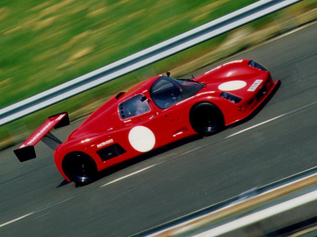 Another view of a red Ultima Sport at a race circuit