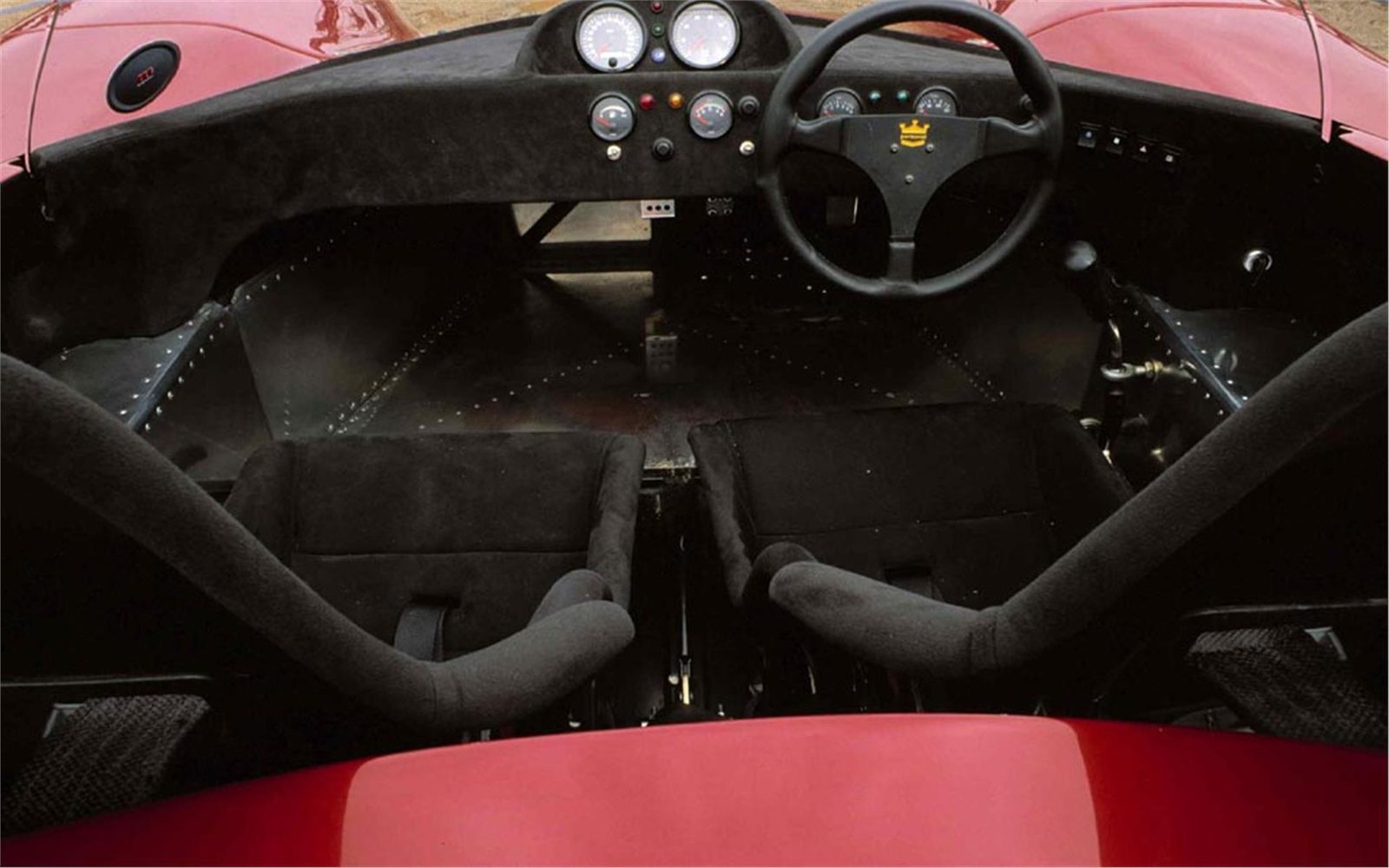Cockpit and steering wheel of a red Ultima Spyder