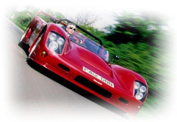 A red Ultima Spyder photographed on the road