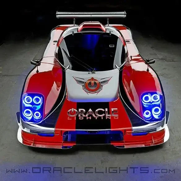Front view of a red-and-white Ultima GTR with four blue headlamp halos illuminated.