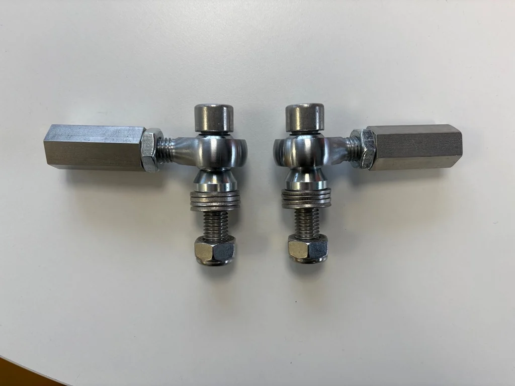 Pair of assembled bump-steer adjusters laid side by side