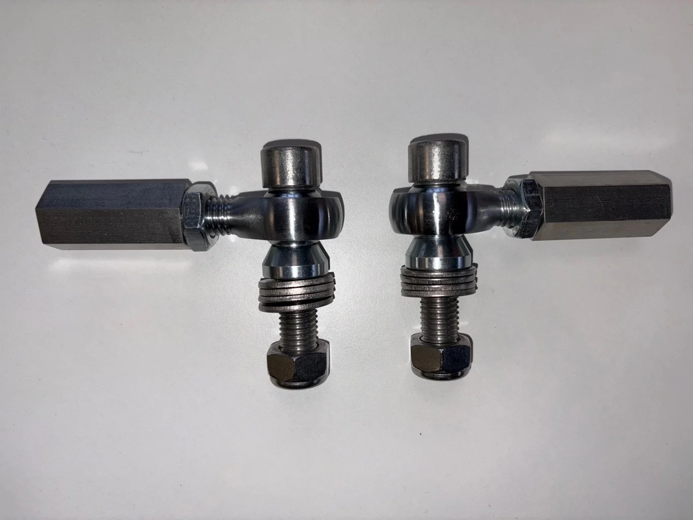 Pair of bump-steer adjusters with threaded bolts visible