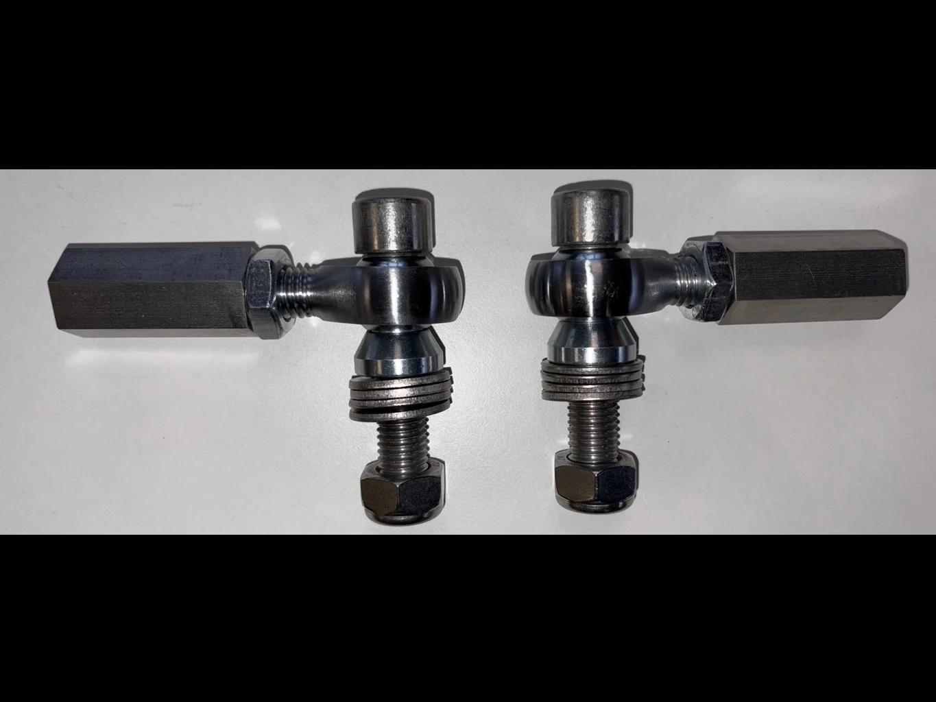 Pair of bump-steer adjusters against a white background