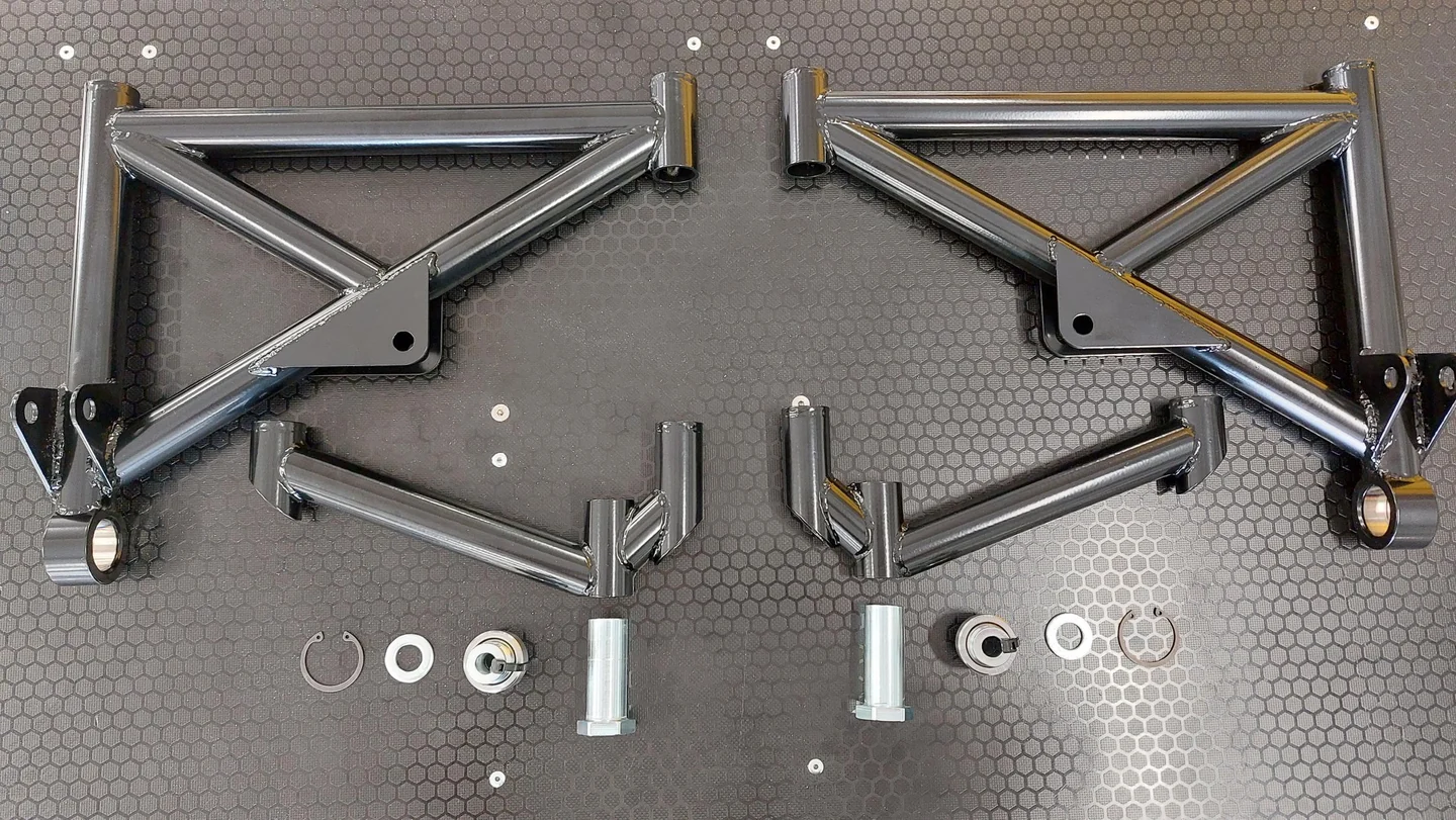 Complete rear wishbone kit and hardware laid out on a workbench